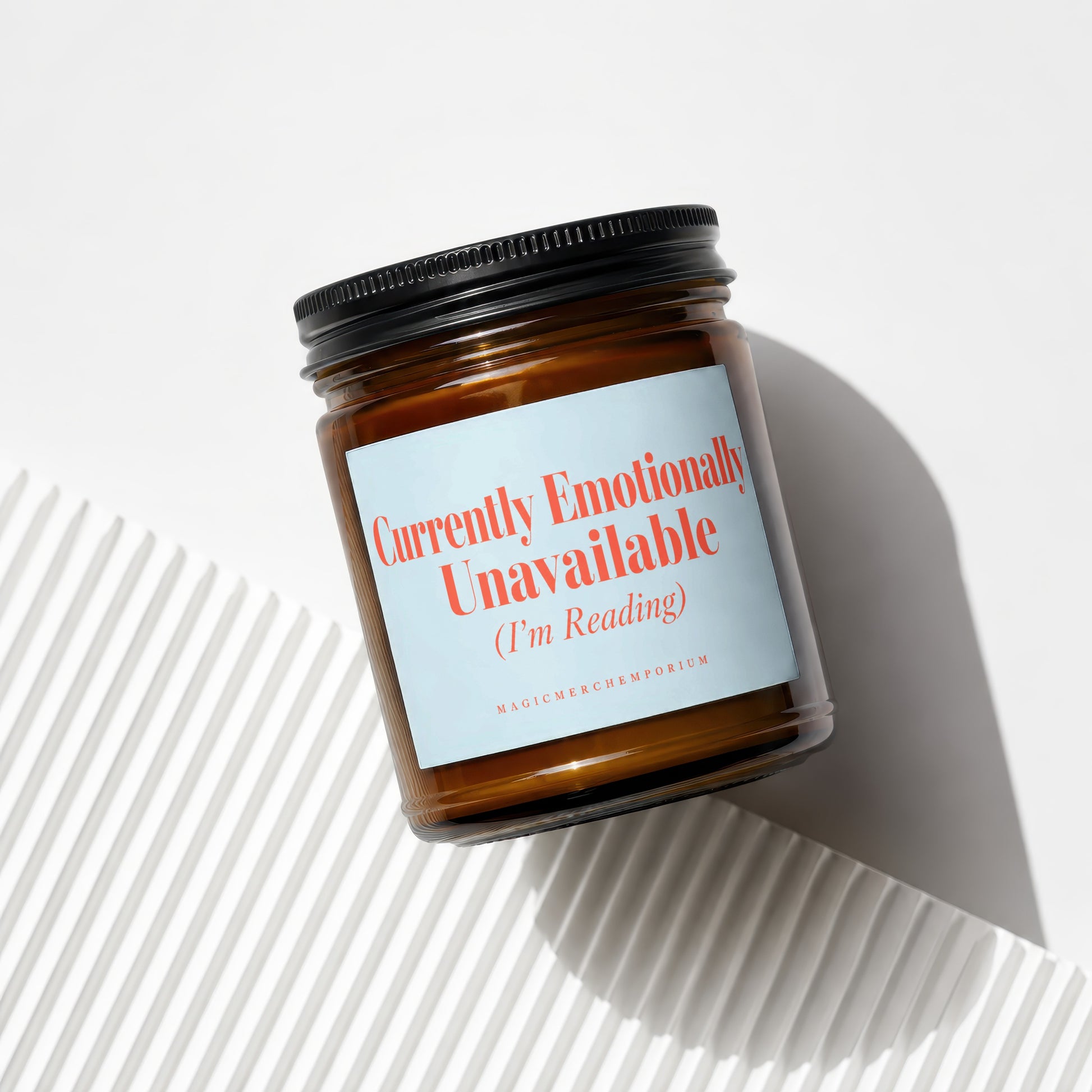 Brown glass candle with a light blue label reading "Currently Emotionally Unavailable (I'm Reading)".