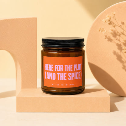 Amber glass candle with label that reads "HERE FOR THE PLOT (AND THE SPICE)".