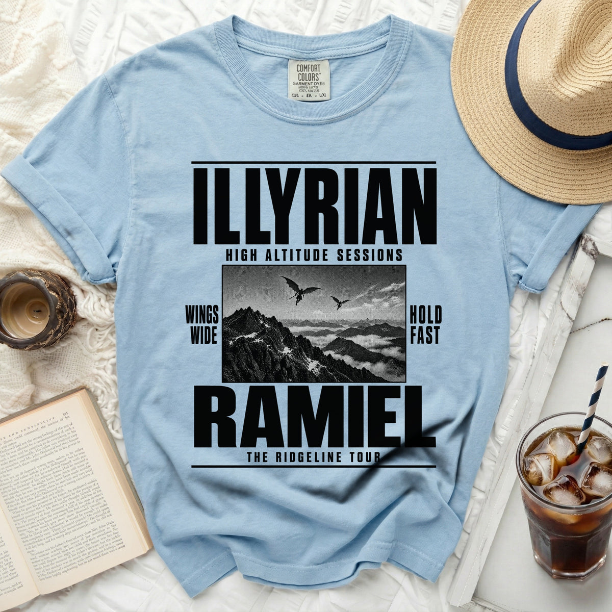 Light blue t-shirt with black text and graphic: "ILLYRIAN HIGH ALTITUDE SESSIONS", mountains, and birds.