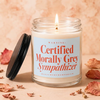 Lit glass candle with "Certified Morally Grey Sympathizer" text on label.