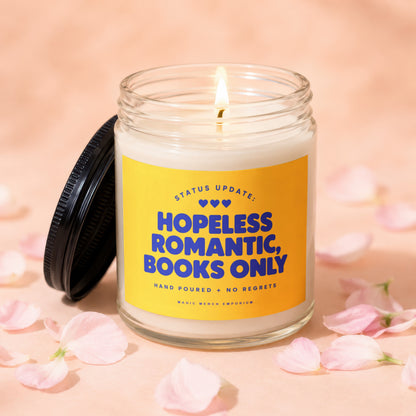 Candle with yellow label reading "Hopeless Romantic, Books Only" and "Magic Merch Emporium".