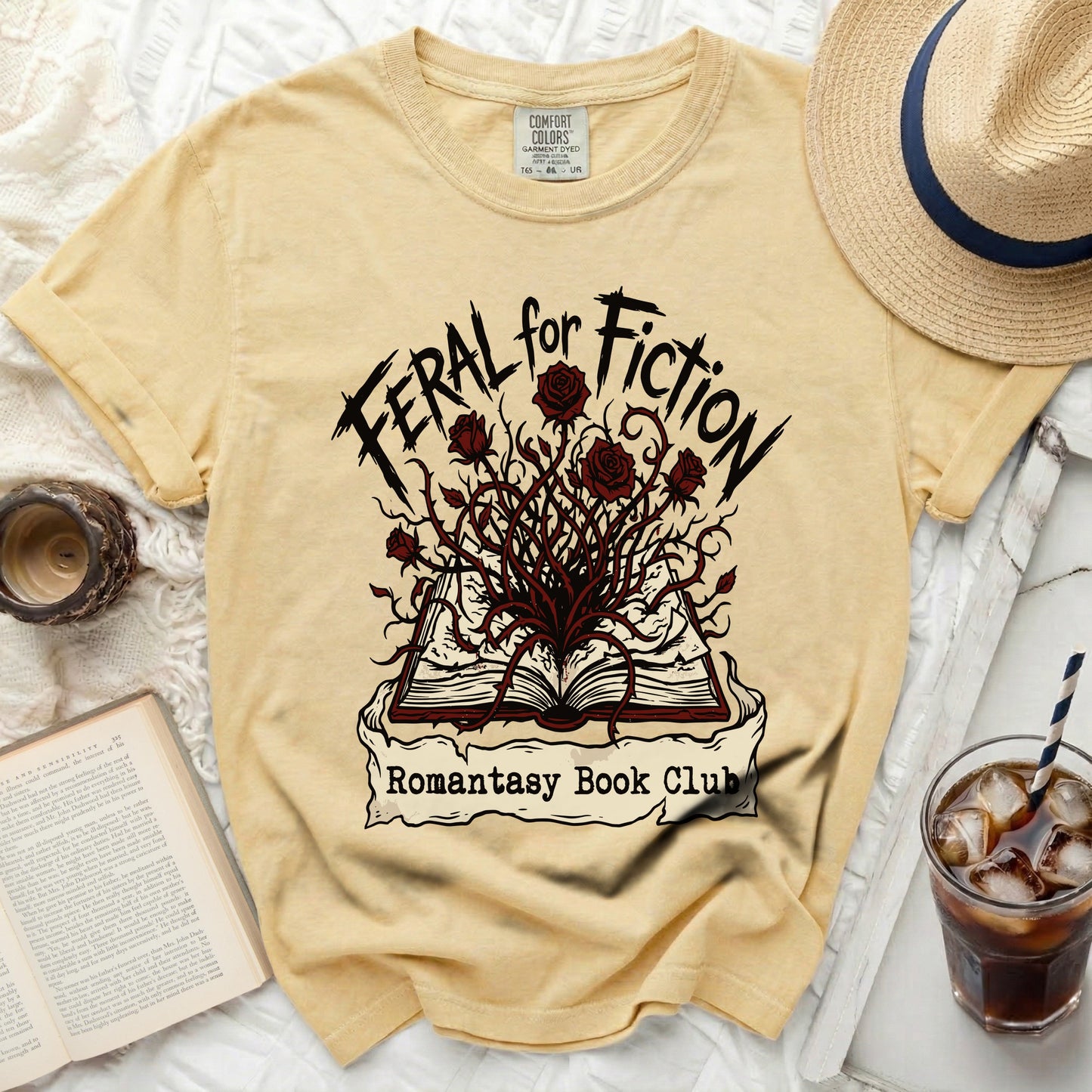 Yellow t-shirt with "Feral for Fiction" and "Romantasy Book Club" graphics.