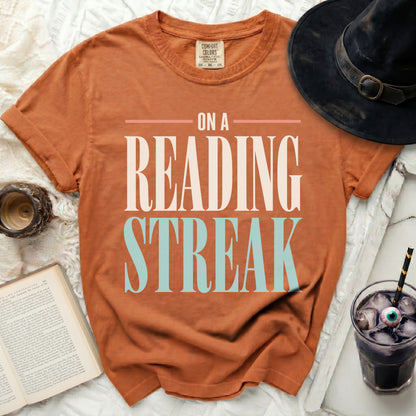 Orange t-shirt with "On a Reading Streak" text, witch hat, book, and spooky drink.