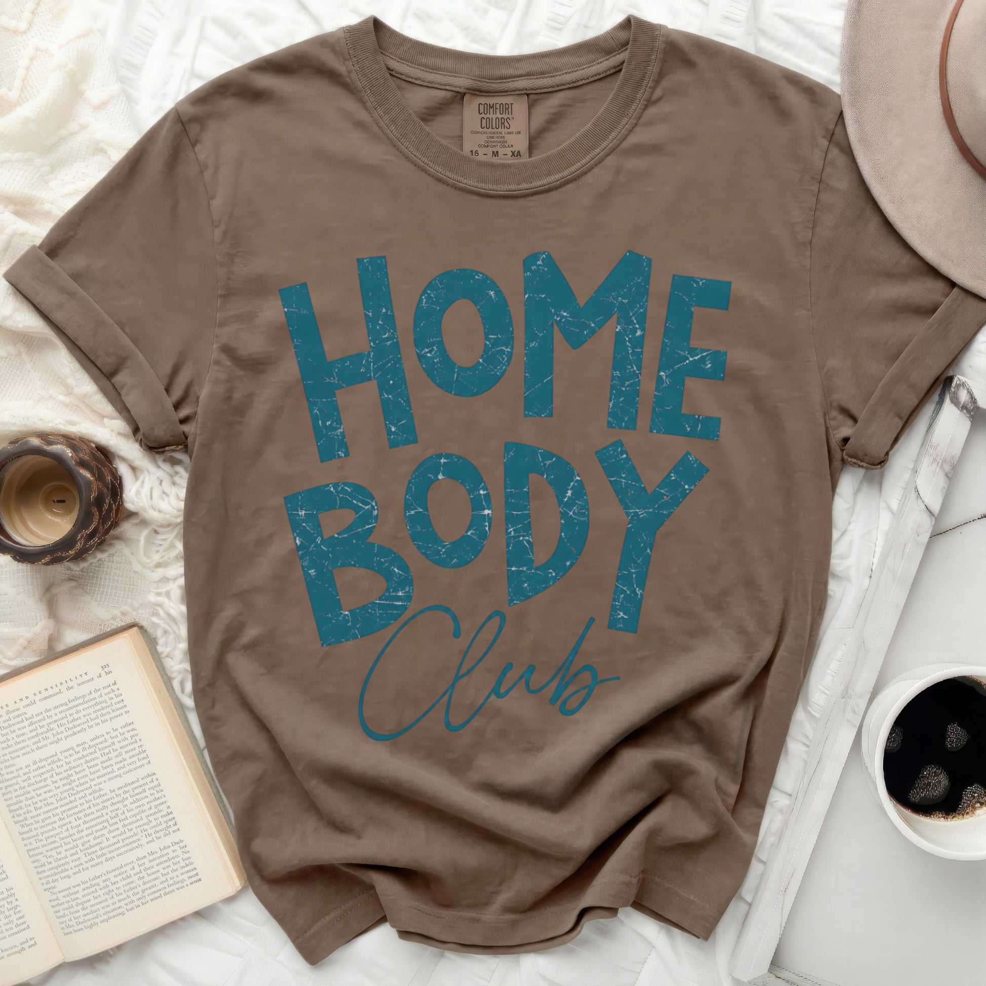 Brown t-shirt with "HOME BODY Club" graphic print in blue.