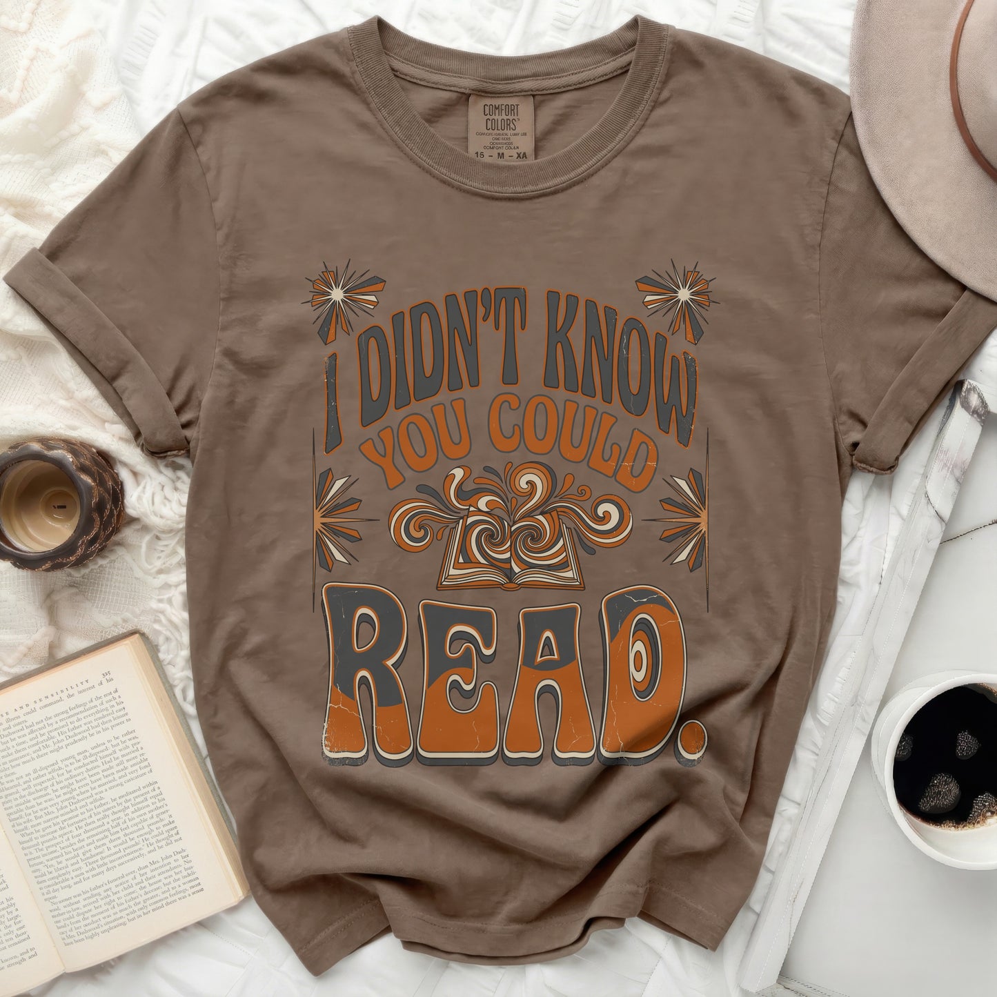 Brown t-shirt with "I didn't know you could read" graphic and open book.