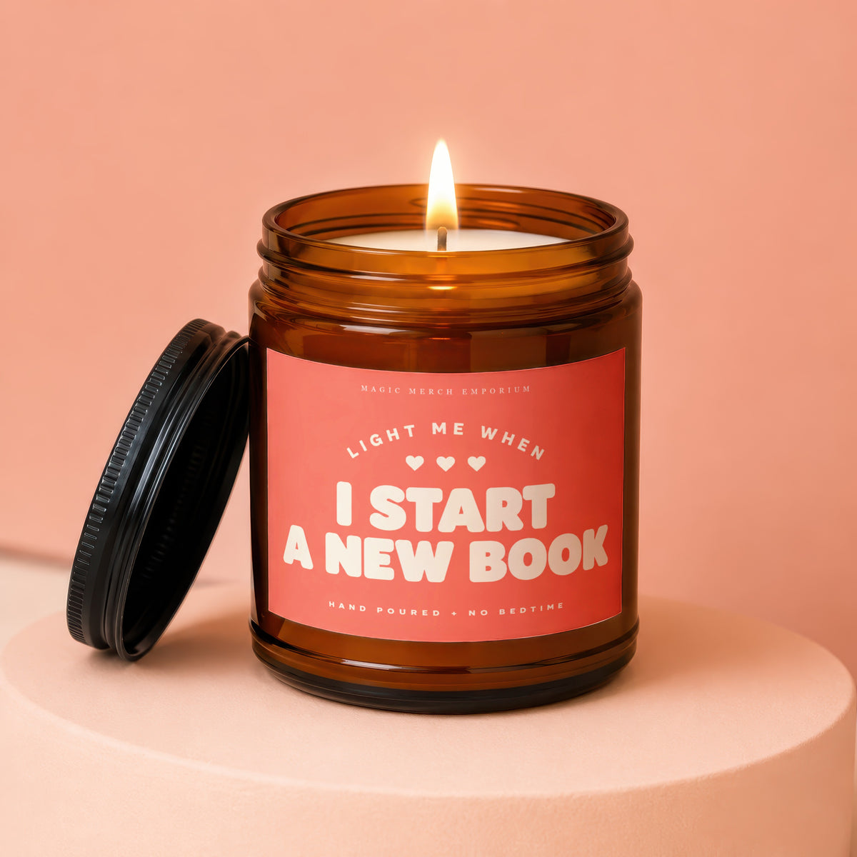 Amber jar candle with lit wick and text "I Start A New Book".