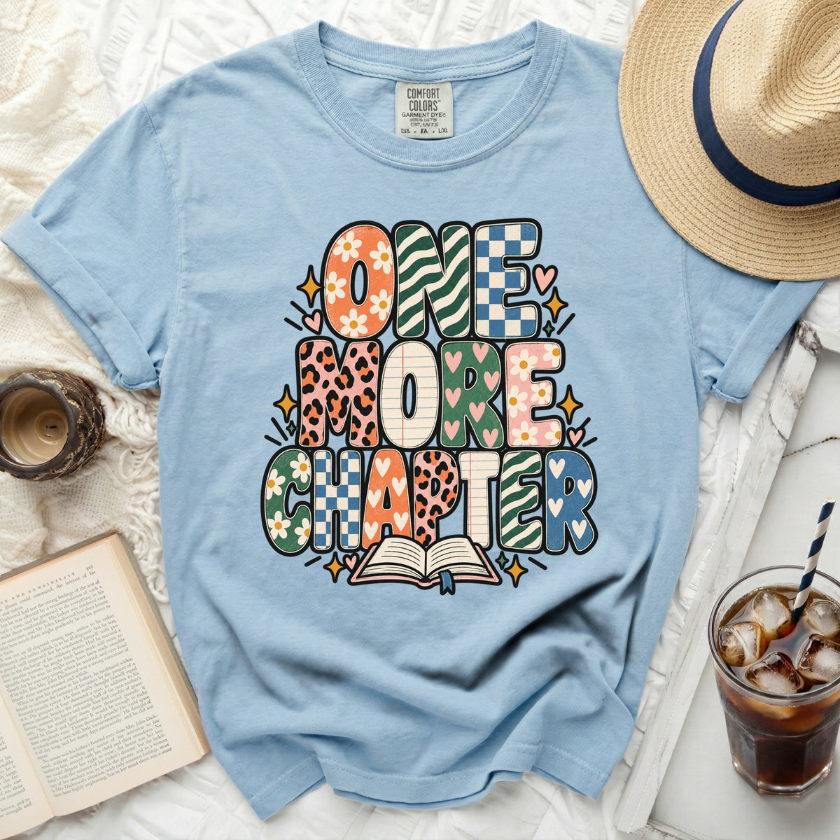 Light blue t-shirt with "ONE MORE CHAPTER" text and an open book graphic.
