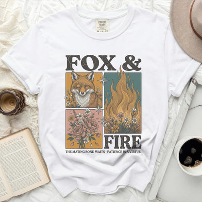 White t-shirt with a graphic design featuring a fox, flames, and flowers, and text.