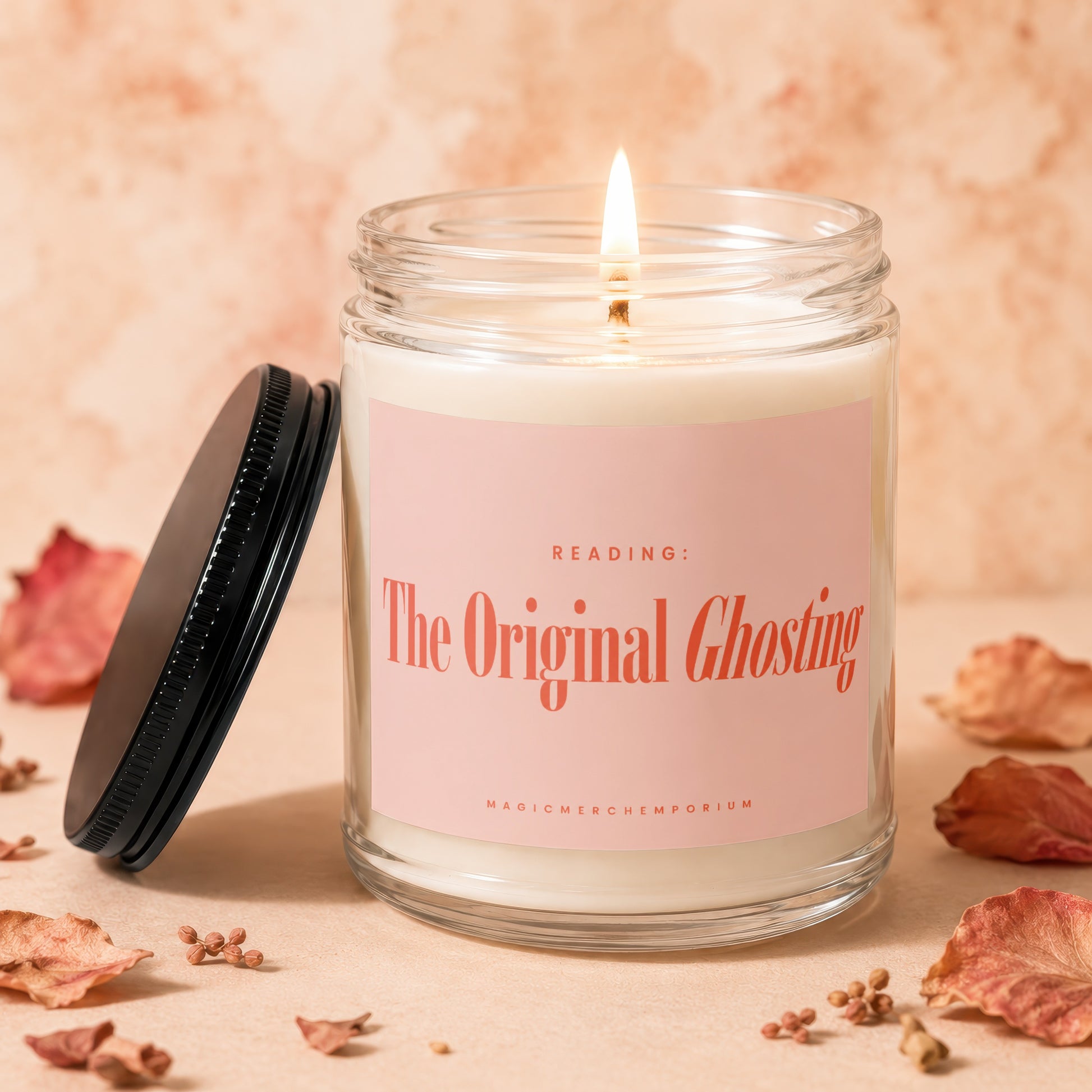 Lit glass candle with pink label text "The Original Ghosting" next to its lid.