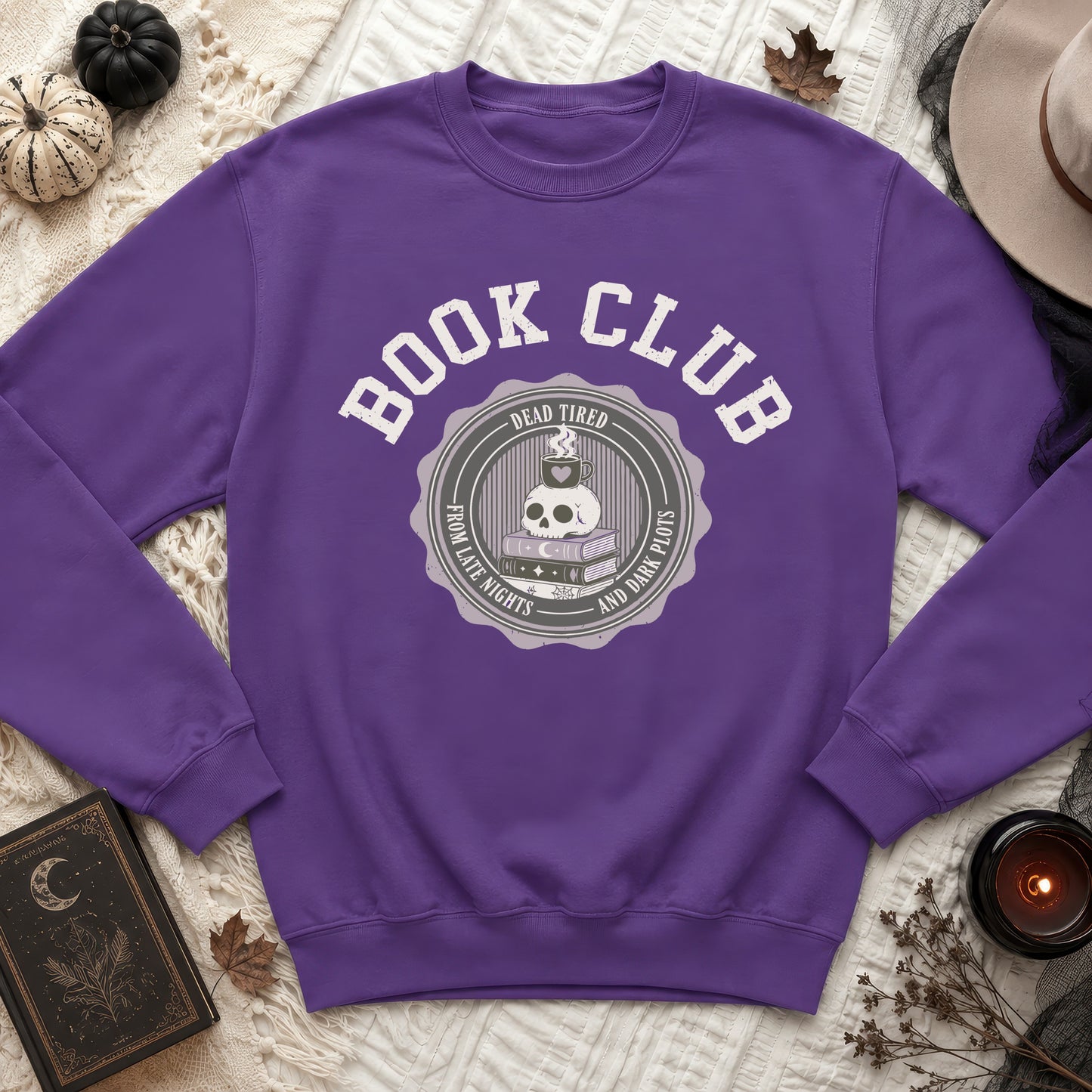 Purple sweatshirt with "Book Club" graphic featuring a skull, coffee cup, and books.