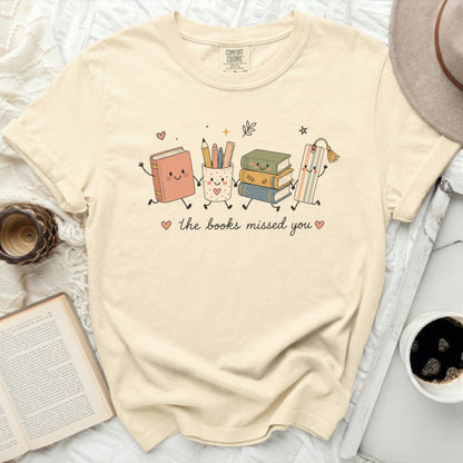 Cute t-shirt with cartoon books, pencil cup, and bookmark saying "the books missed you".