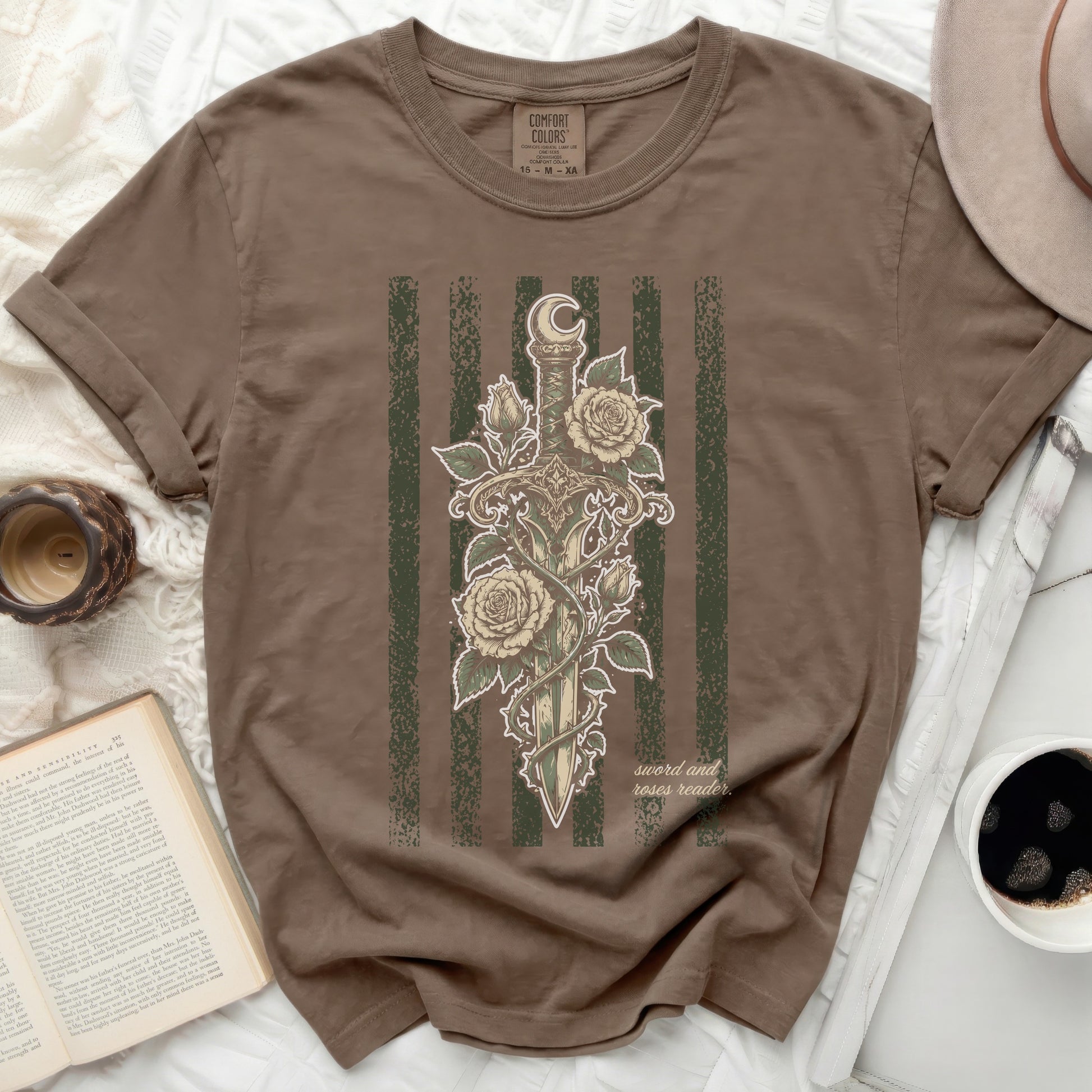 Brown t-shirt with a sword and roses design and "sword and roses reader" text.
