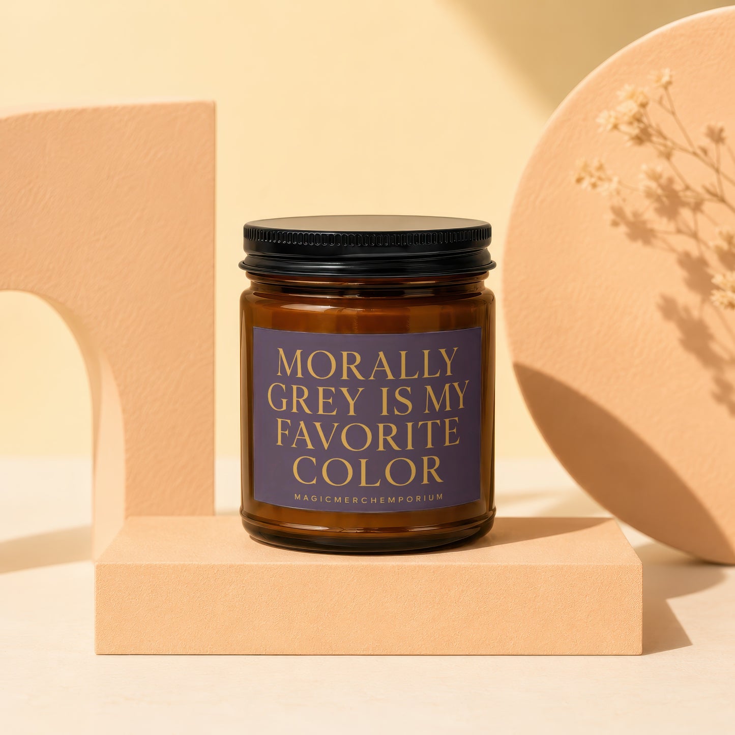 Brown glass candle with black lid and a purple label reading "Morally Grey Is My Favorite Color".