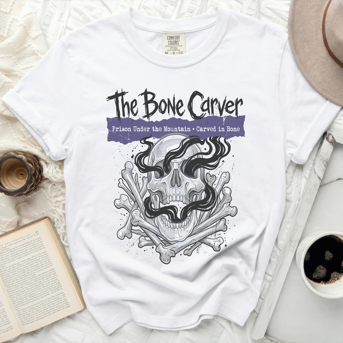 White Comfort Colors t-shirt with "The Bone Carver" graphic.
