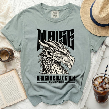 Light blue t-shirt with "MAISE DRAGON COLLECTION THE EMPYREAN" text and dragon graphic.