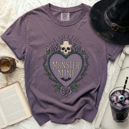 Purple t-shirt with heart-shaped graphic featuring a skull and roses with "MONSTER MINE" text.
