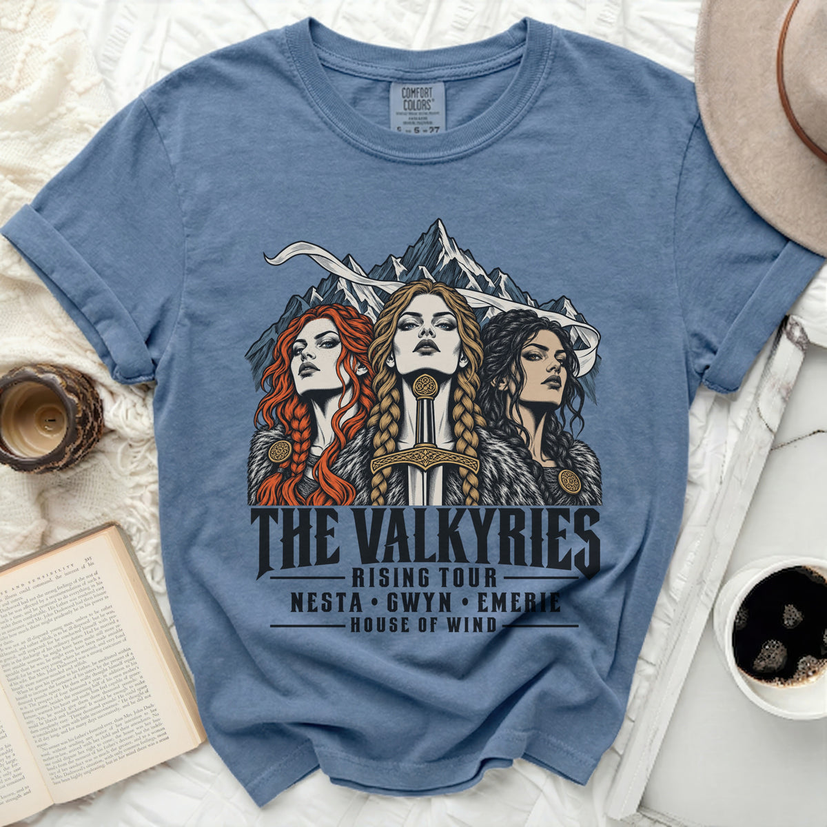 Blue t-shirt featuring "The Valkyries Rising Tour" with names Nesta, Gwyn, Emerie.