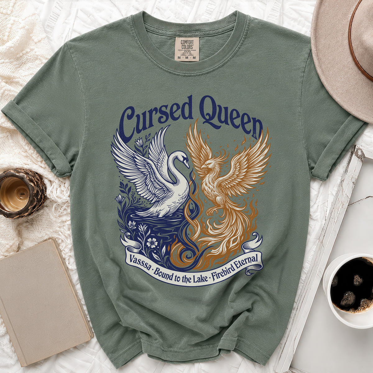 Green t-shirt with Cursed Queen design featuring a swan and phoenix.