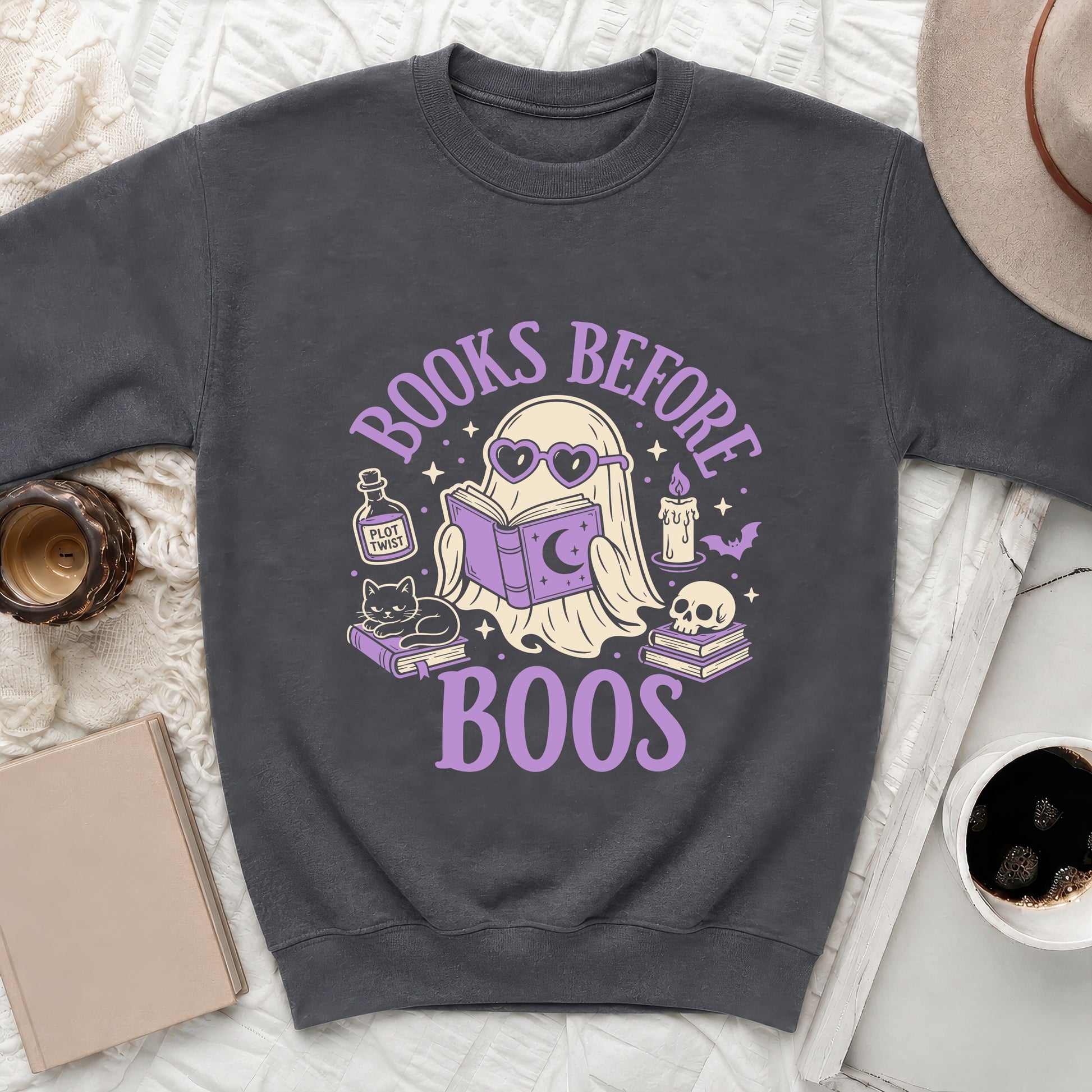 Dark gray sweatshirt with a graphic of a ghost reading and text "Books Before Boos".