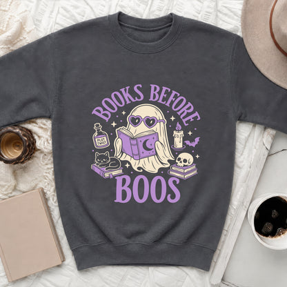 Dark gray sweatshirt with a graphic of a ghost reading and text "Books Before Boos".