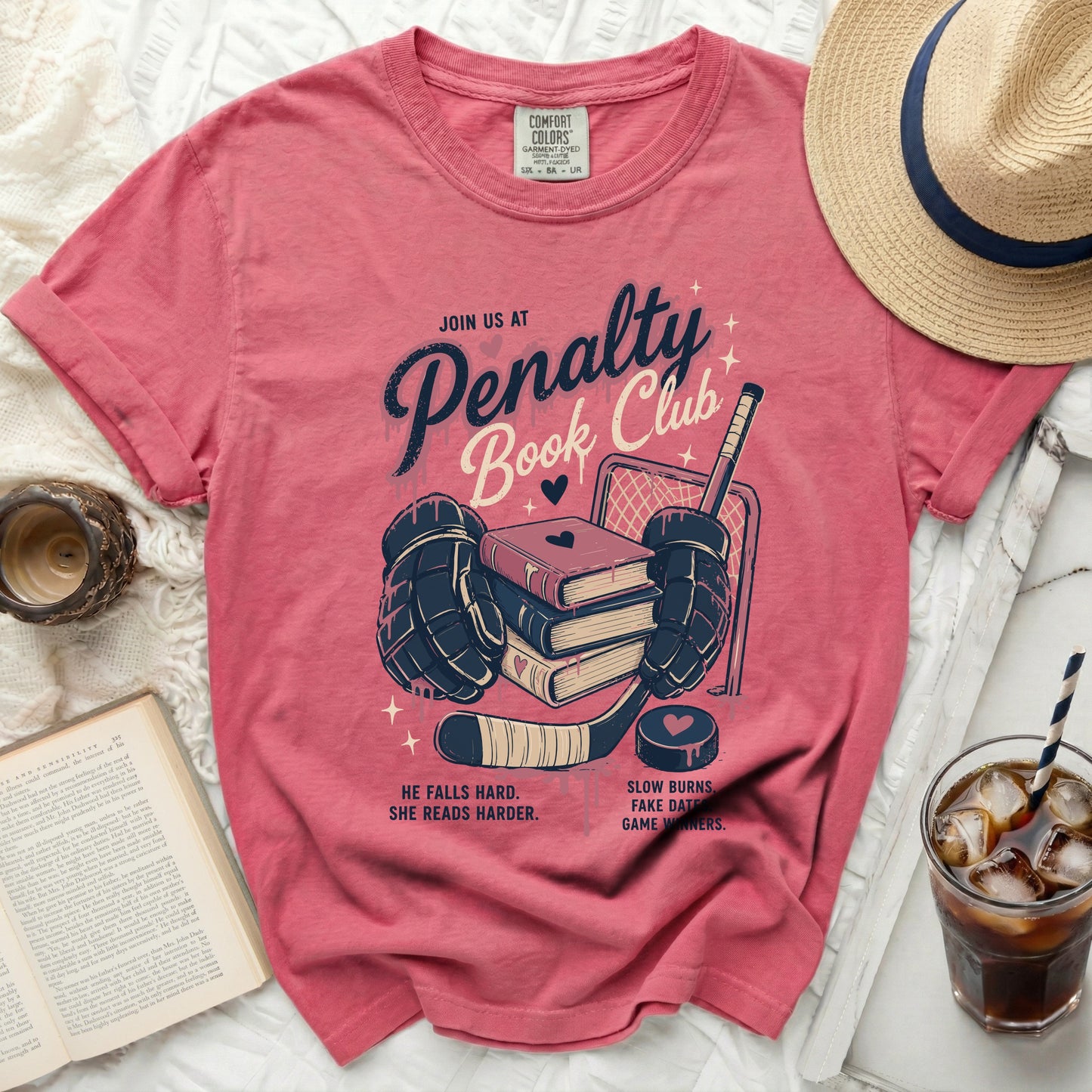 Pink t-shirt with "Penalty Book Club" text and hockey imagery.