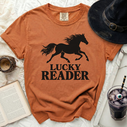 Orange t-shirt with black silhouette of running horse and "LUCKY READER" text.