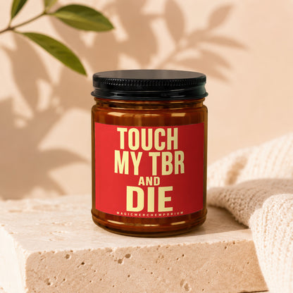 Amber jar candle with red label reading "TOUCH MY TBR AND DIE MAGICMERCHEDMPORIUM".
