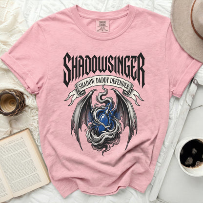 Pink t-shirt with "Shadowsinger Shadow Daddy Defender" graphic and blue soda bottle.
