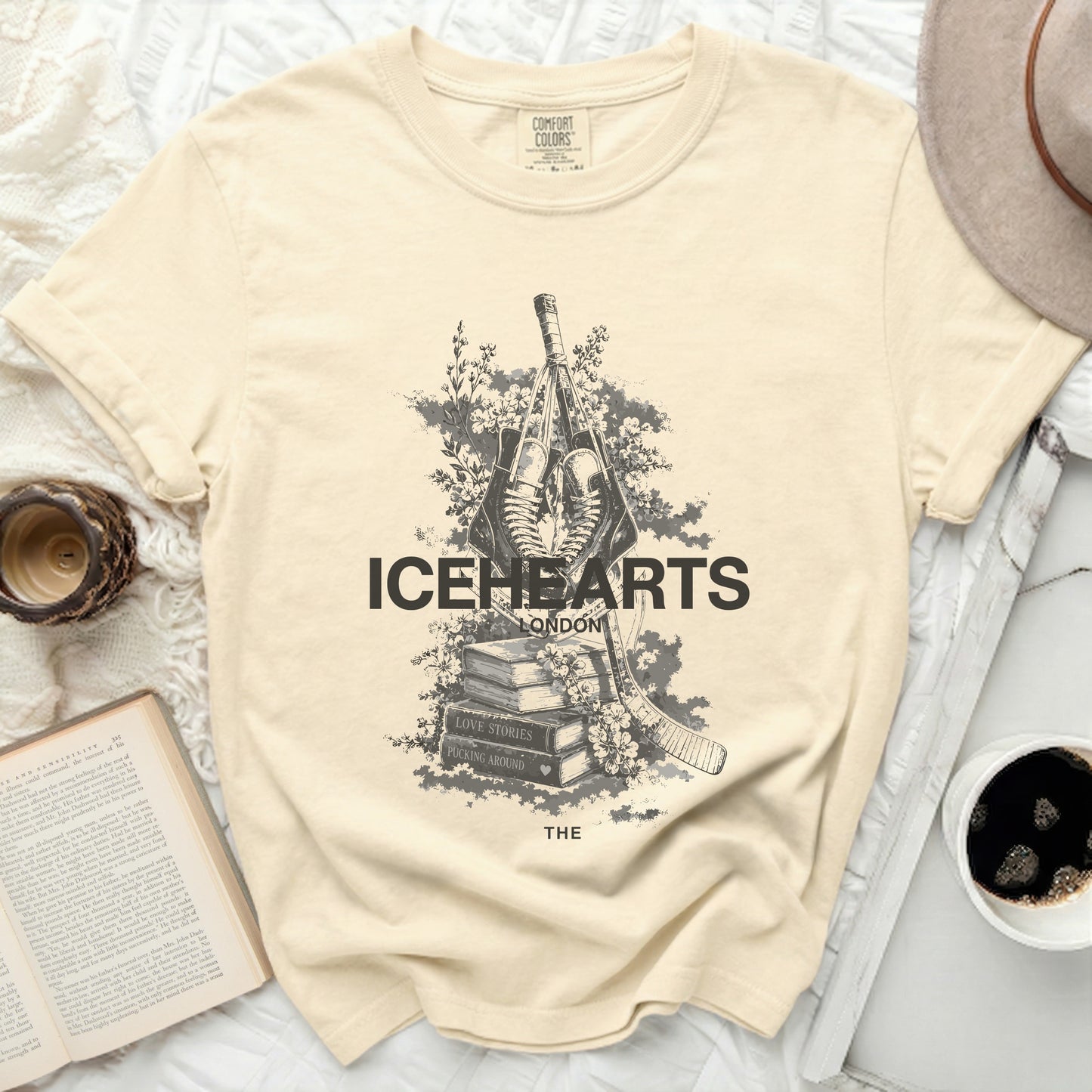 Cream t-shirt with ICEHEARTS LONDON graphic featuring hockey sticks and skates.