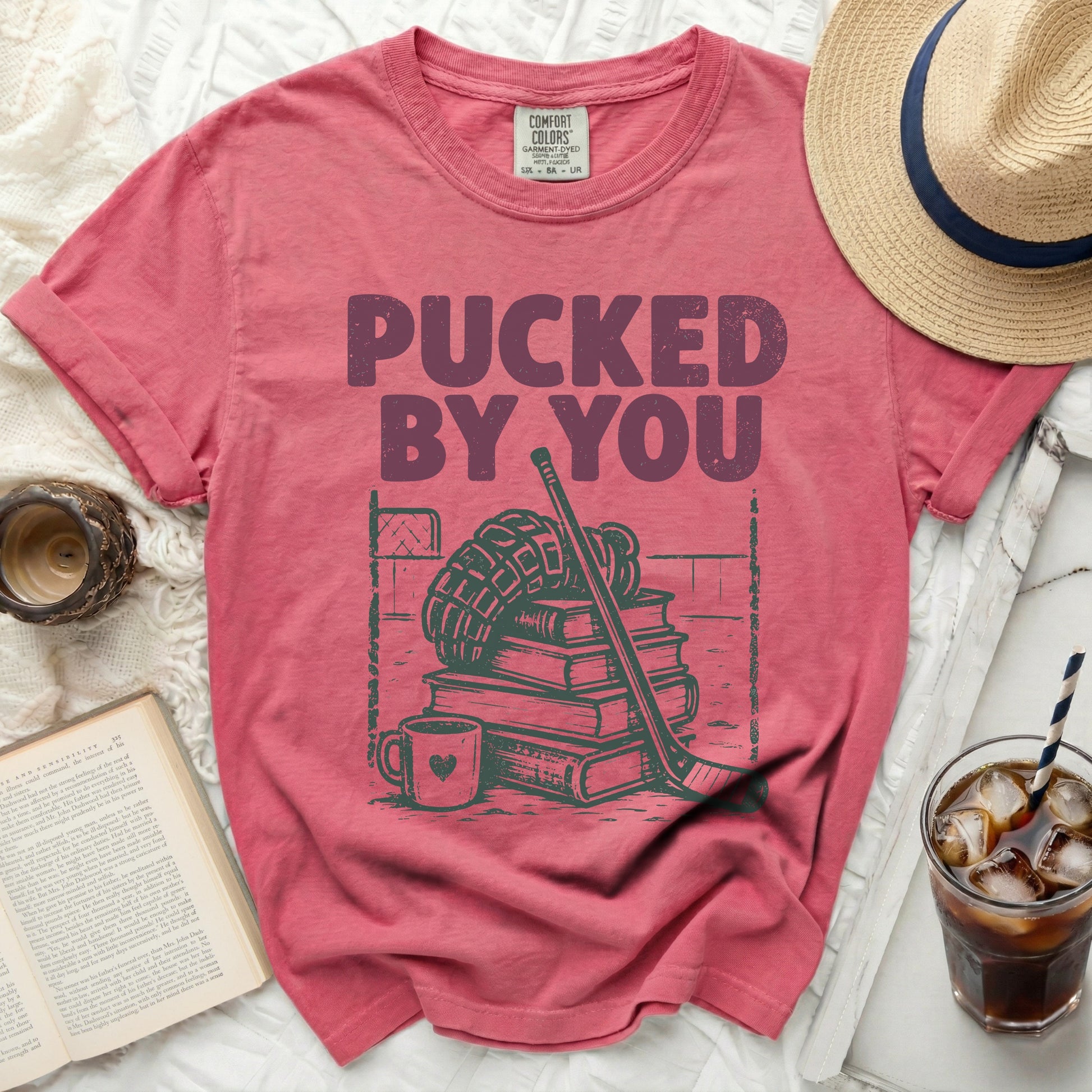 Red t-shirt with "PUCKED BY YOU" text, hockey puck, and book graphic.