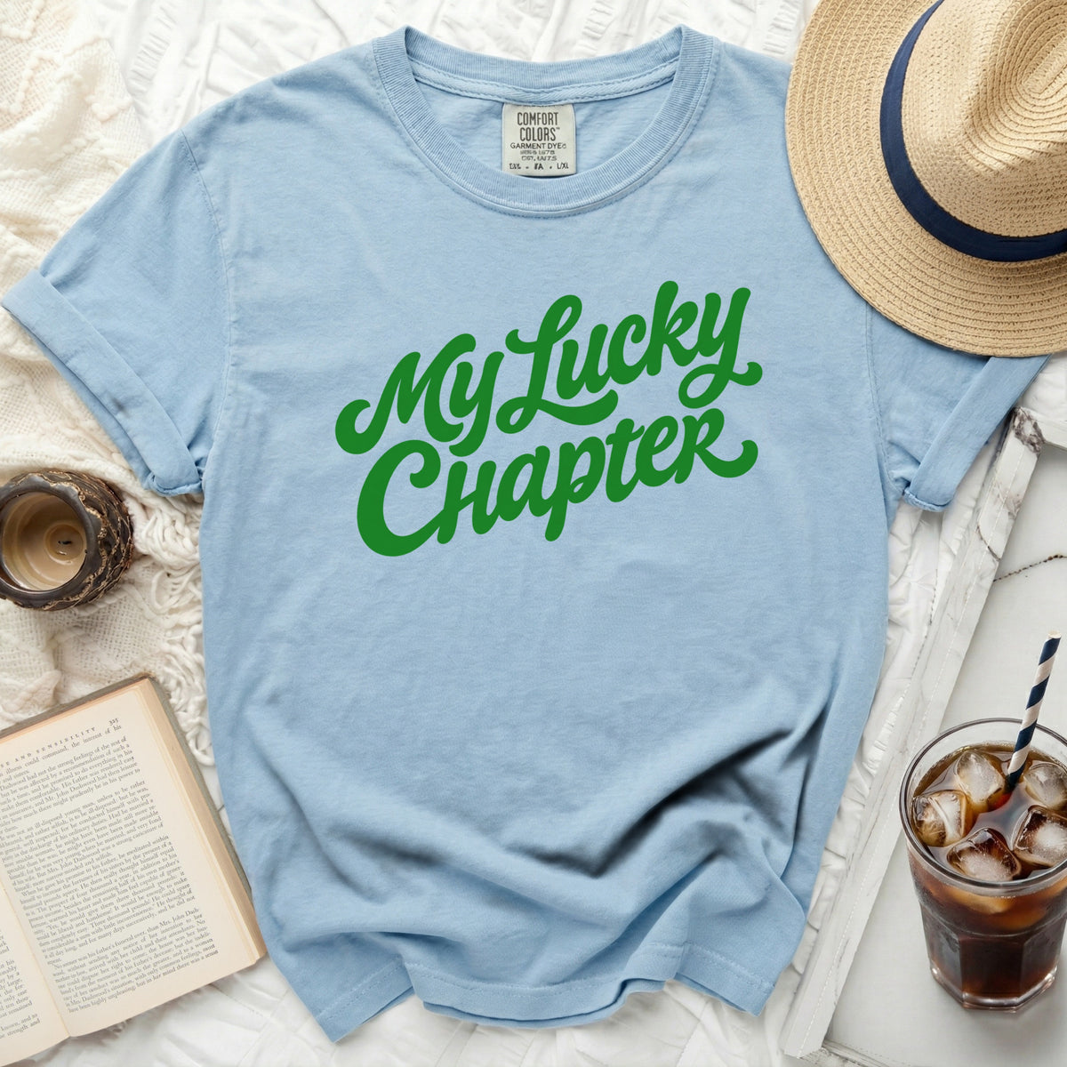 Light blue t-shirt with green text that reads "My Lucky Chapter".