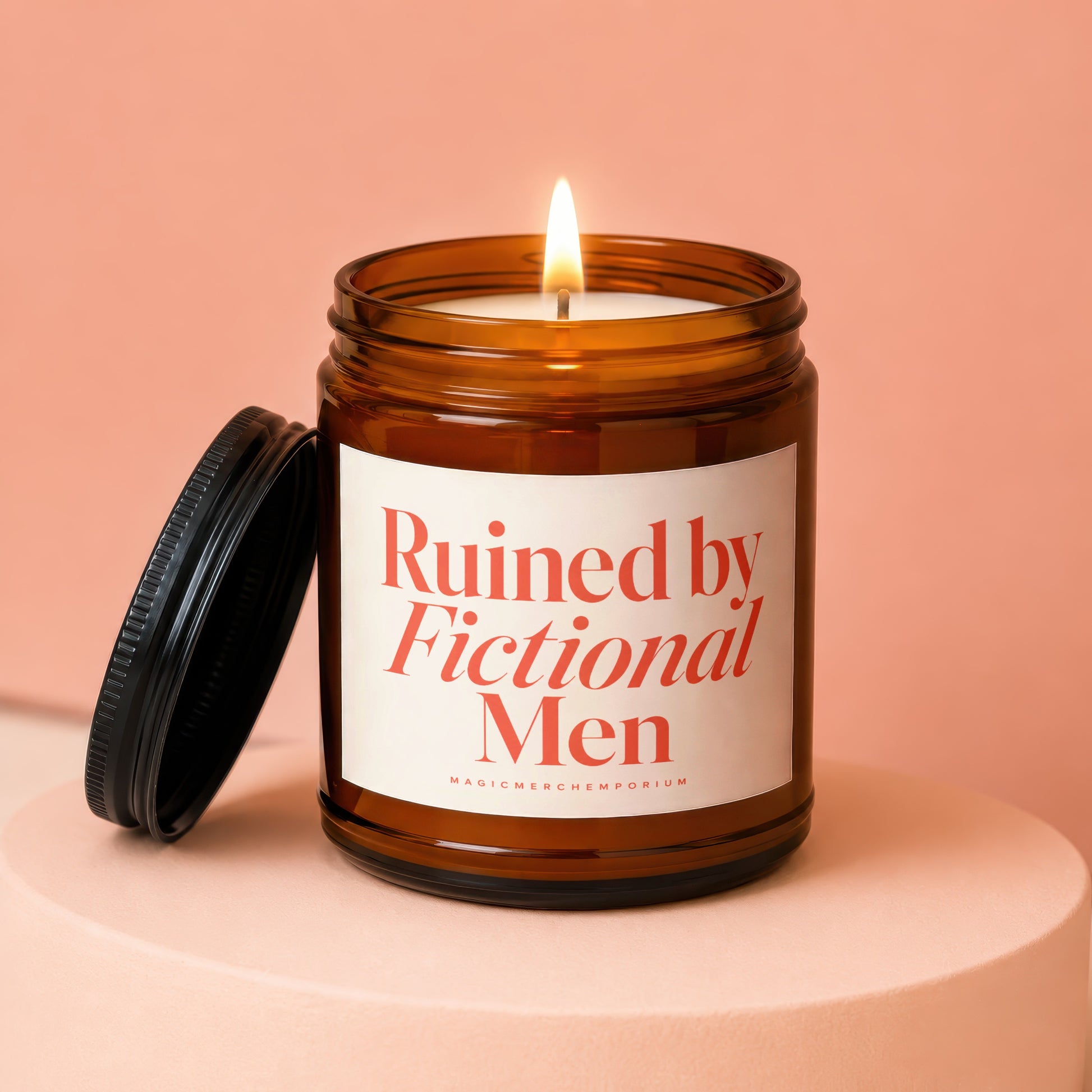 Amber jar candle with lit wick and black lid, reading "Ruined by Fictional Men".