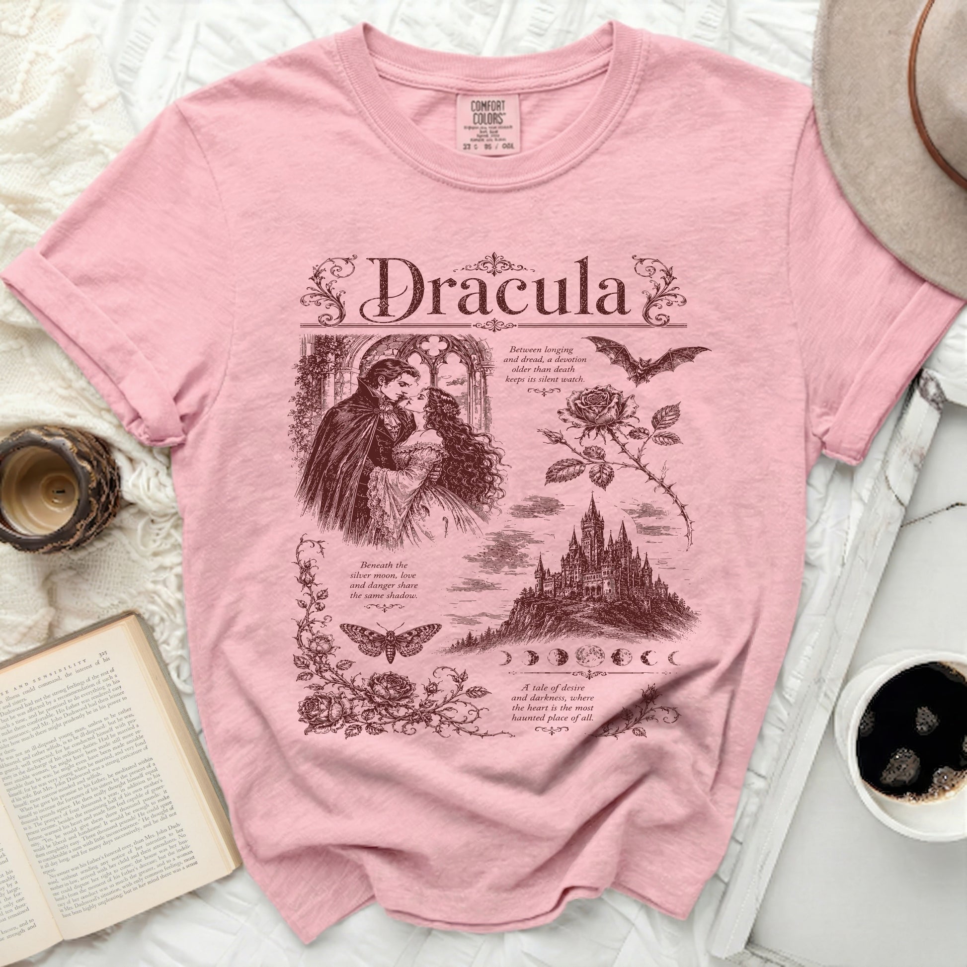 Pink t-shirt with "Dracula" text, gothic couple, castle, bat, and roses.