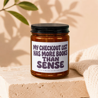 Scented candle with text "my checkout list has more books than sense".