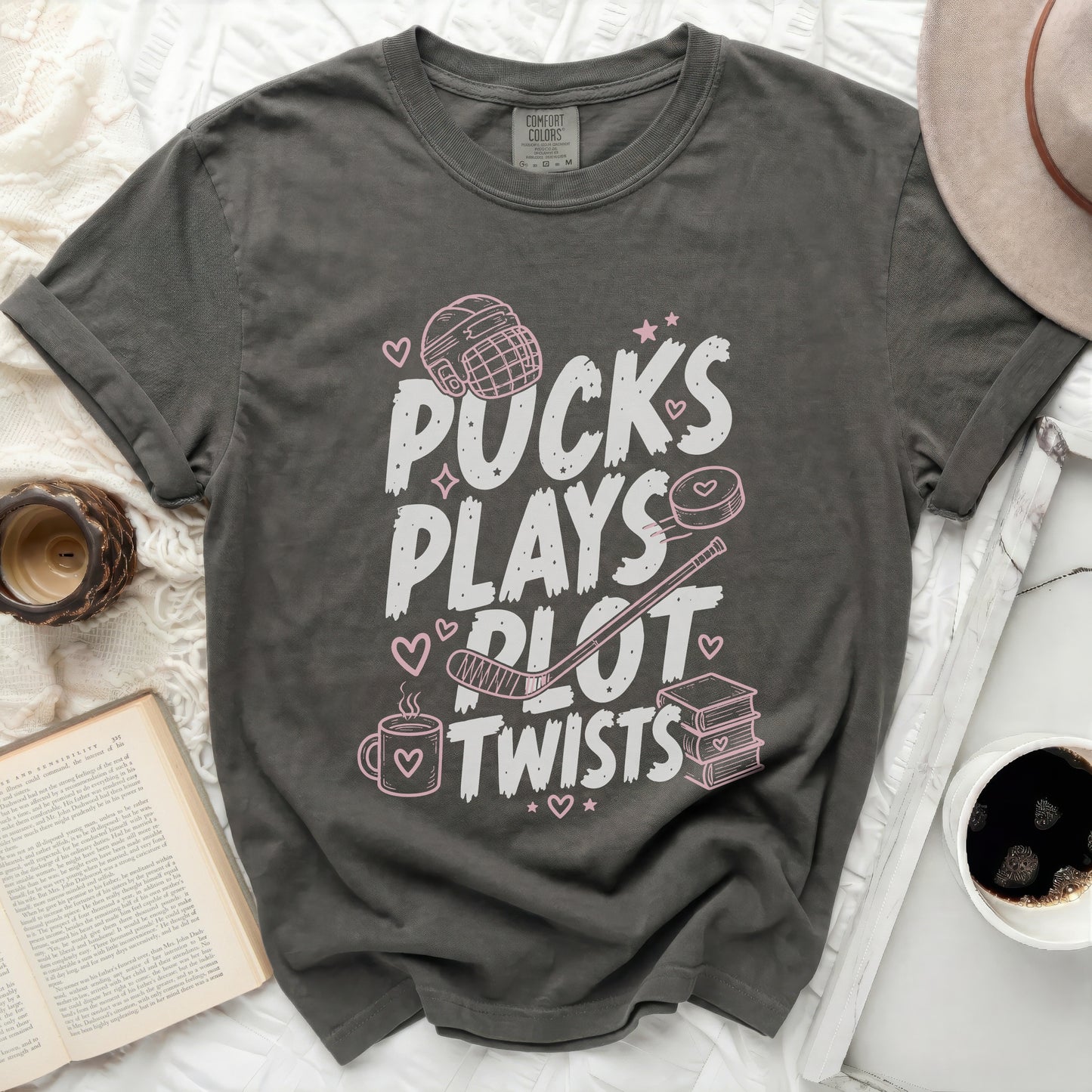 Gray t-shirt with "Pucks Plays Plot Twists" text and hockey graphics.