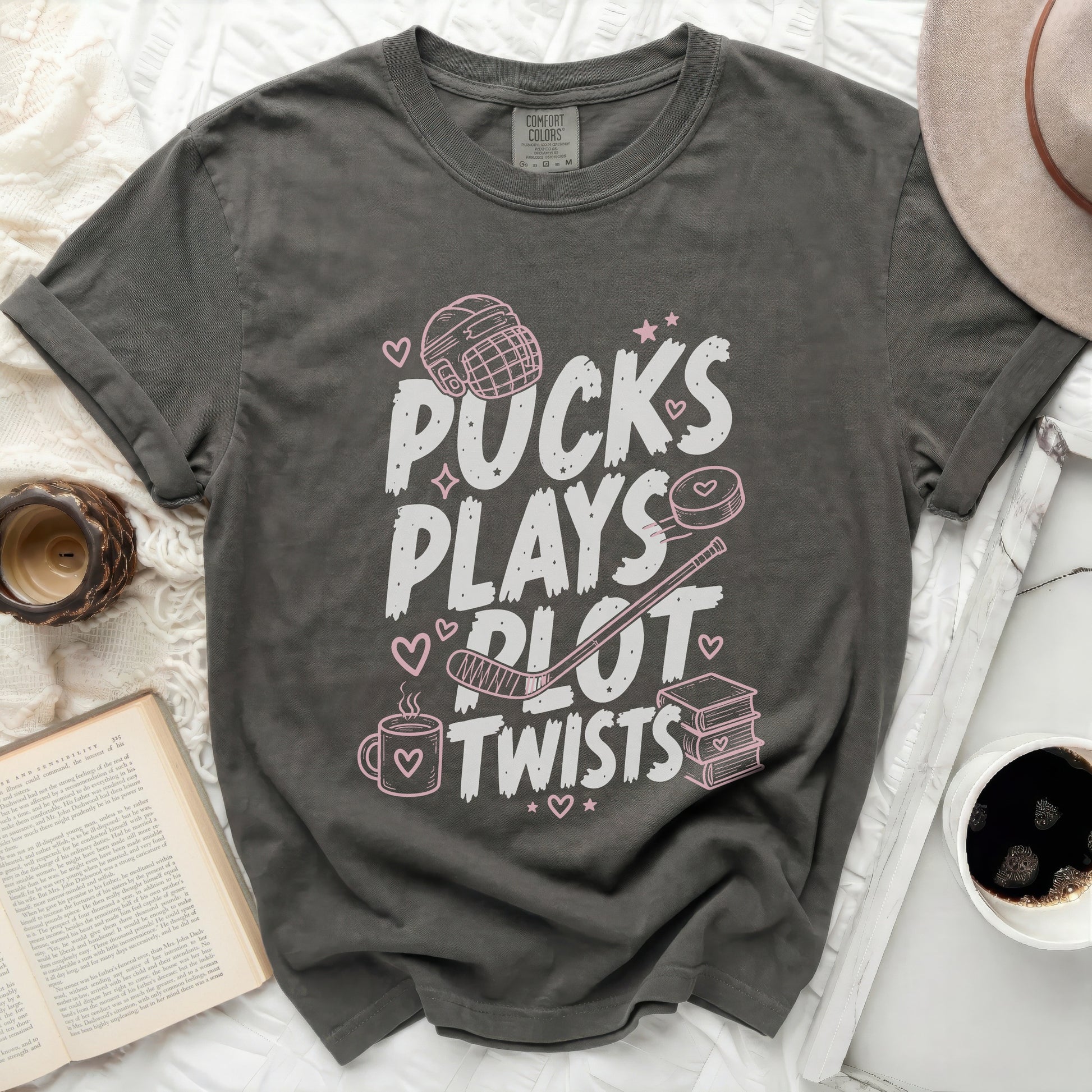 Gray t-shirt with "Pucks Plays Plot Twists" text and hockey graphics.