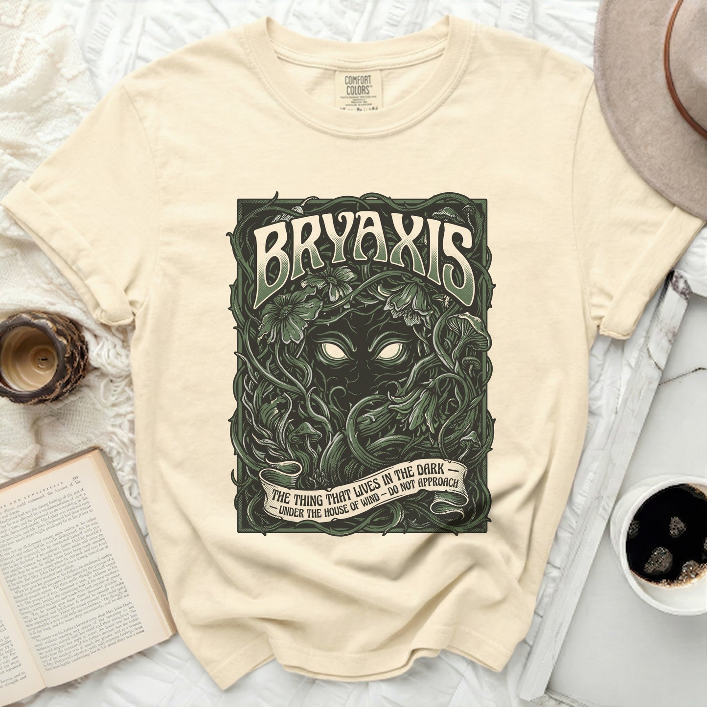 Cream Comfort Colors t-shirt with "Bryaxis" and vine graphics, and the text "The Thing That Lives In The Dark."