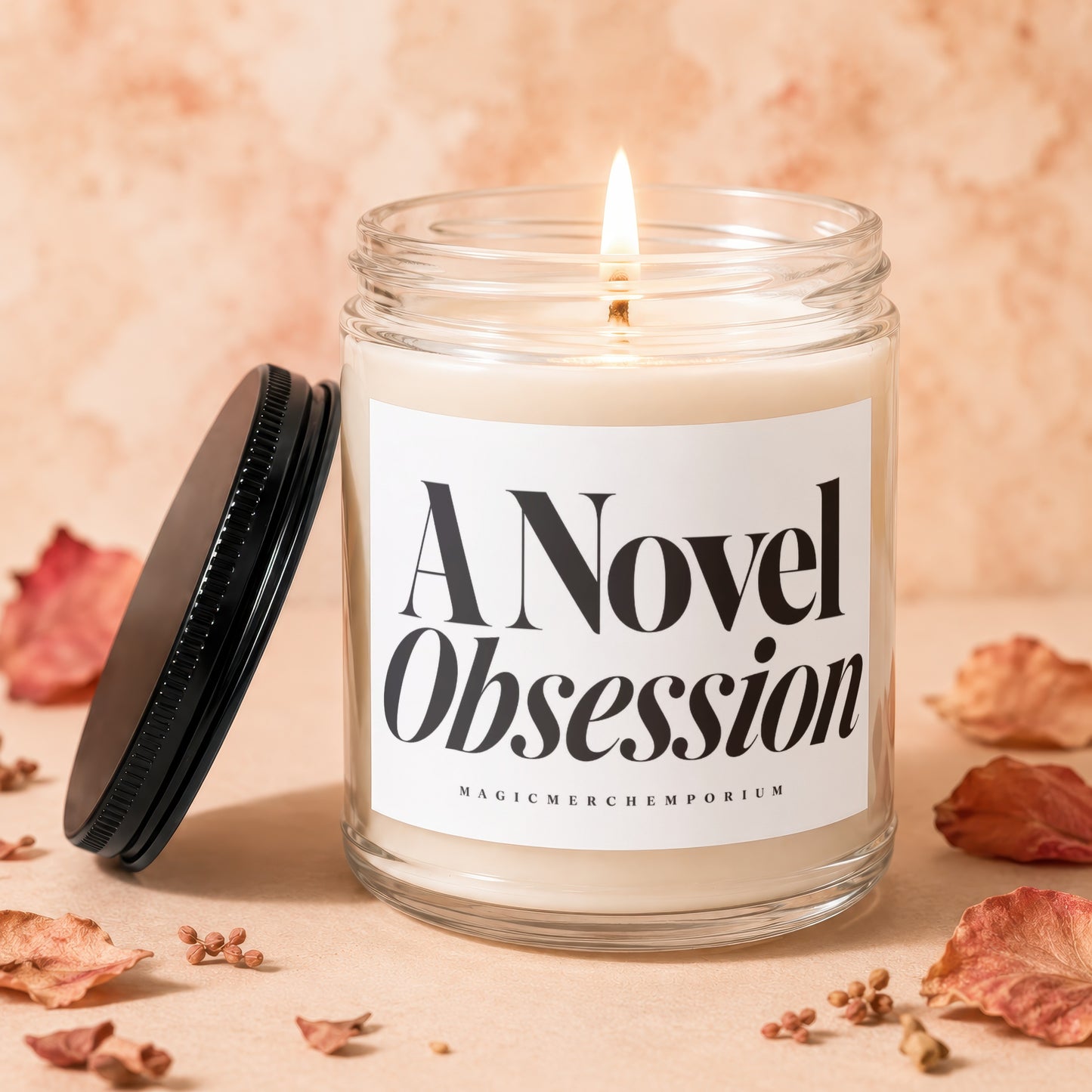 A Novel Obsession candle in a glass jar with a lit wick and black lid.