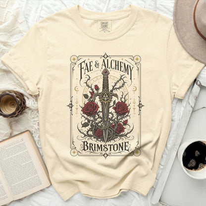 Cream t-shirt with Fae & Alchemy text, sword, and roses graphic.