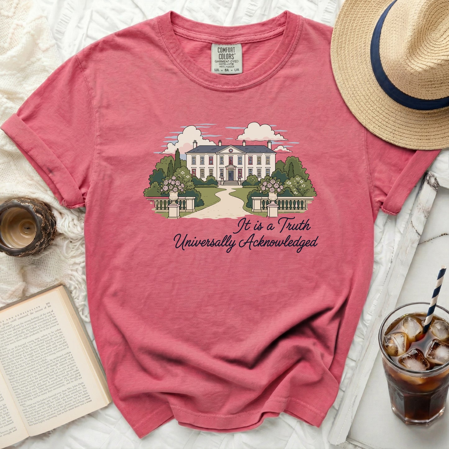 Salmon pink t-shirt with house and trees graphic and text: It is a Truth Universally Acknowledged
