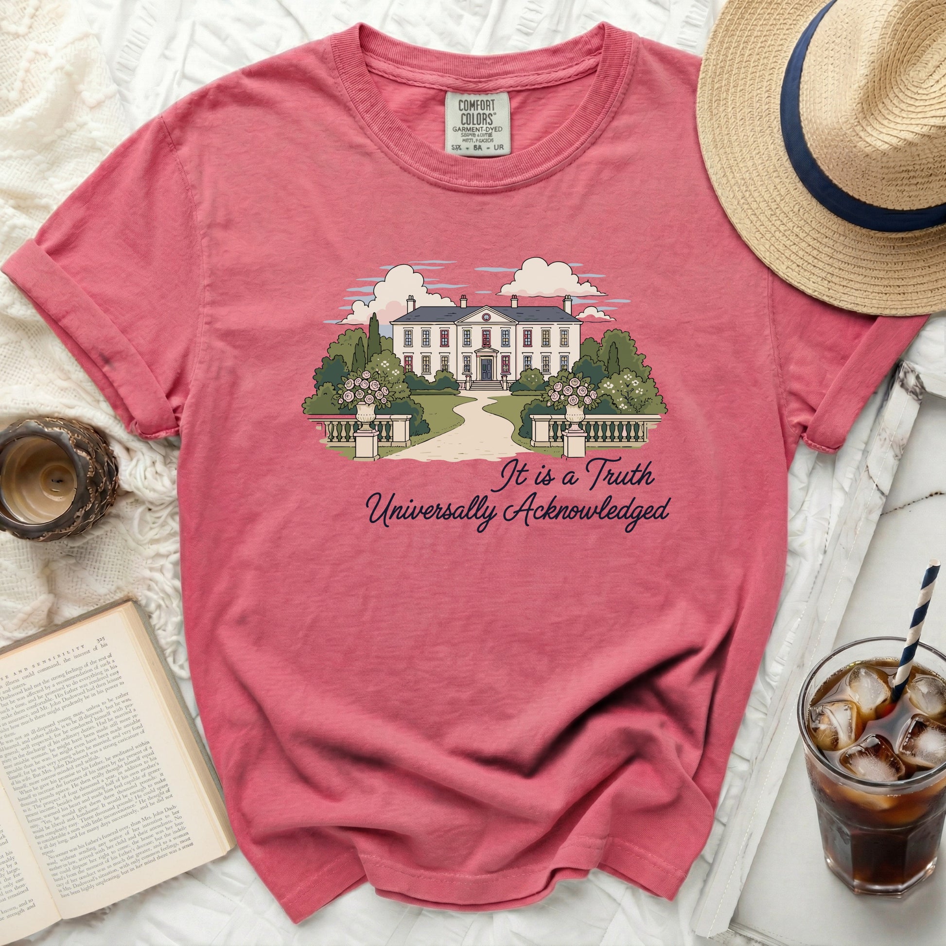 Salmon pink t-shirt with house and trees graphic and text: It is a Truth Universally Acknowledged