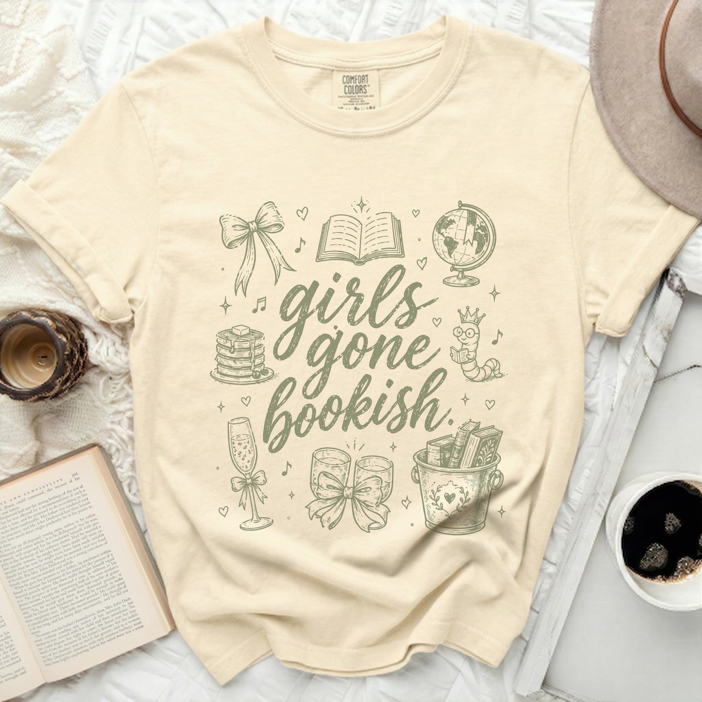 Girls Gone Bookish graphic tee with illustrations of books, a globe, and champagne.