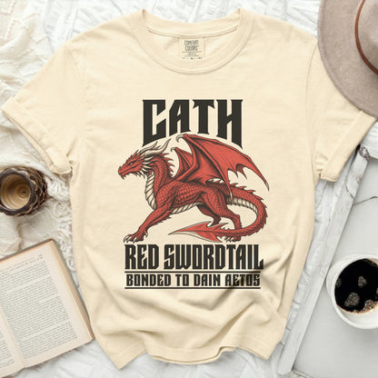 Cream t-shirt with a red dragon graphic and text "CATH RED SWORDTAIL BONDED TO DAIN AETOS".