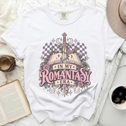 White t-shirt graphic with open book, sword, roses, moons, stars, and "IN MY ROMANTASY ERA".