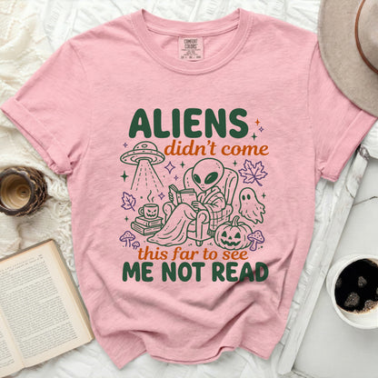 Pink t-shirt with an alien reading a book next to a pumpkin and ghost.