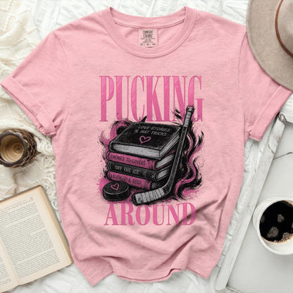 Pink t-shirt with "PUCKING AROUND" text and hockey gear graphic.
