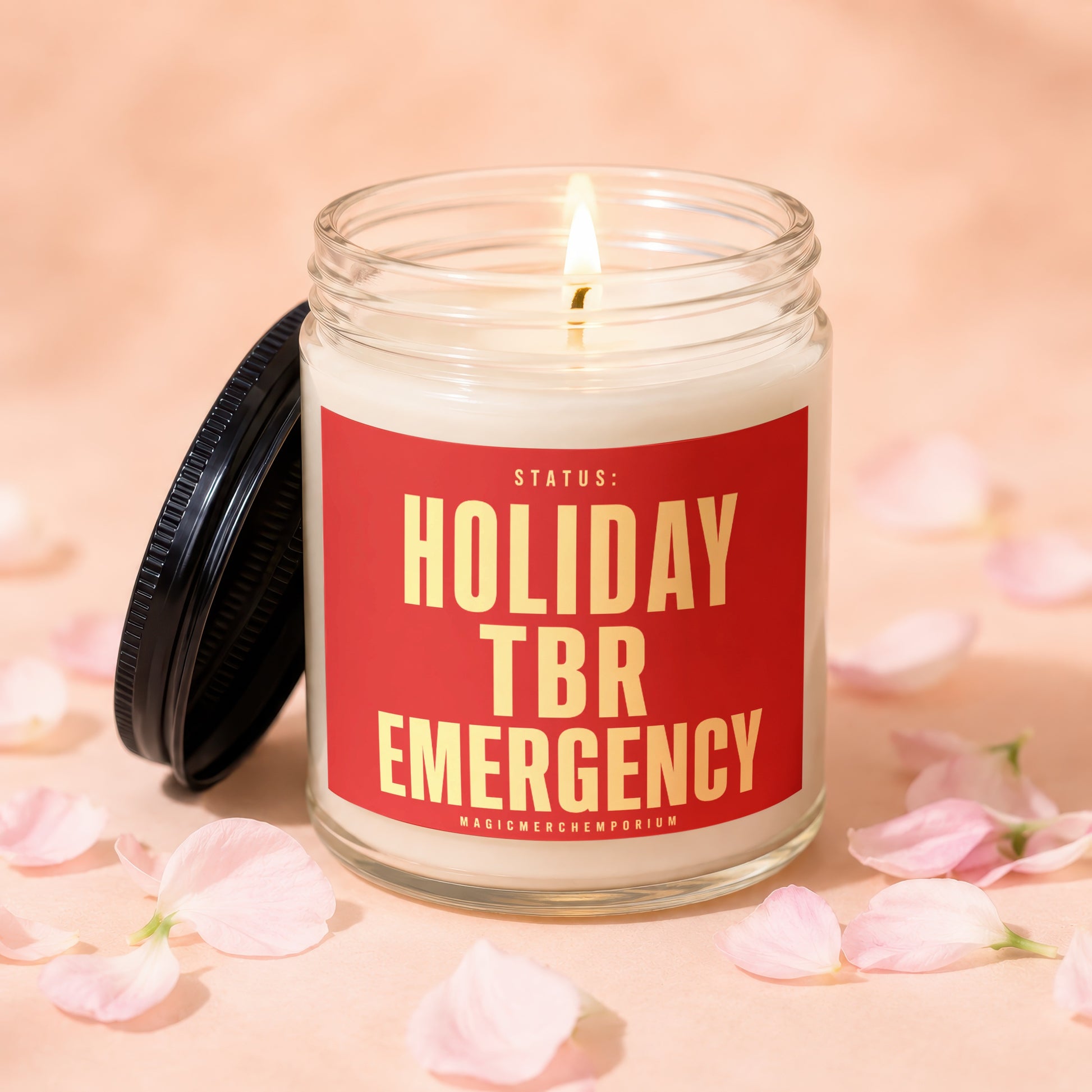 Glass jar candle with lit wick and lid next to it, reads "Holiday TBR Emergency".