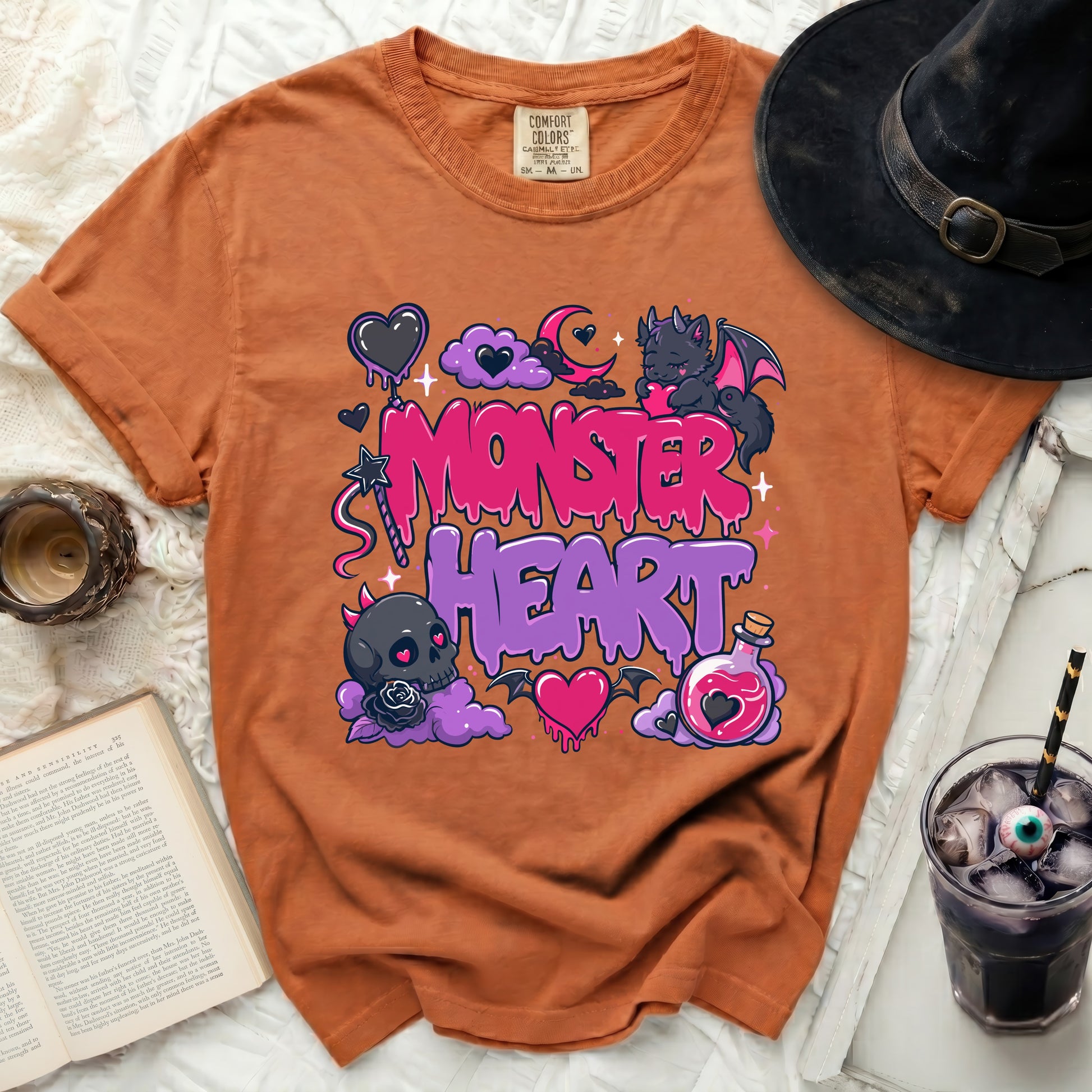 Orange t-shirt with "Monster Heart" graphic, clouds, bat, and potion bottle.