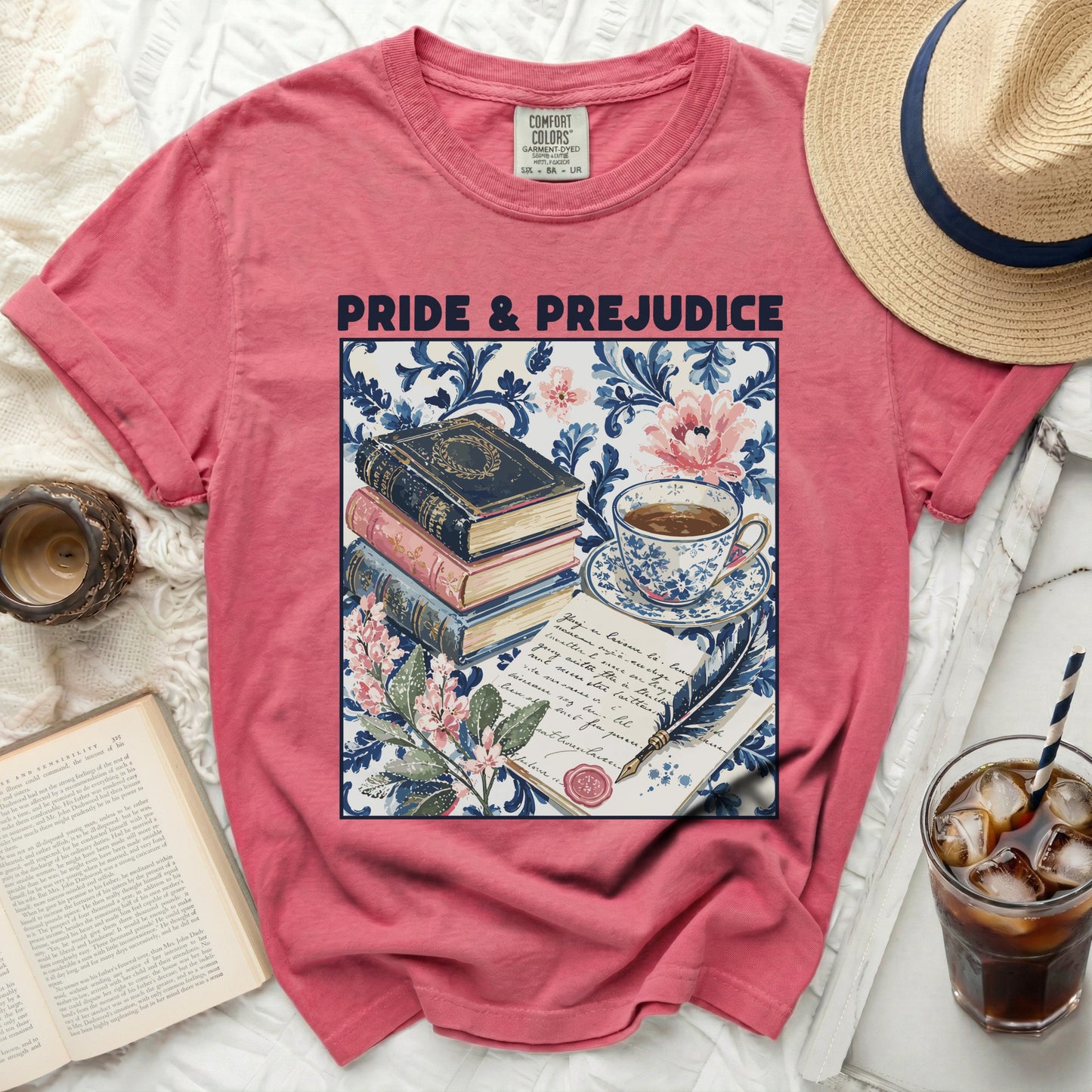 Pink t-shirt with "Pride & Prejudice" and floral design of books and tea.