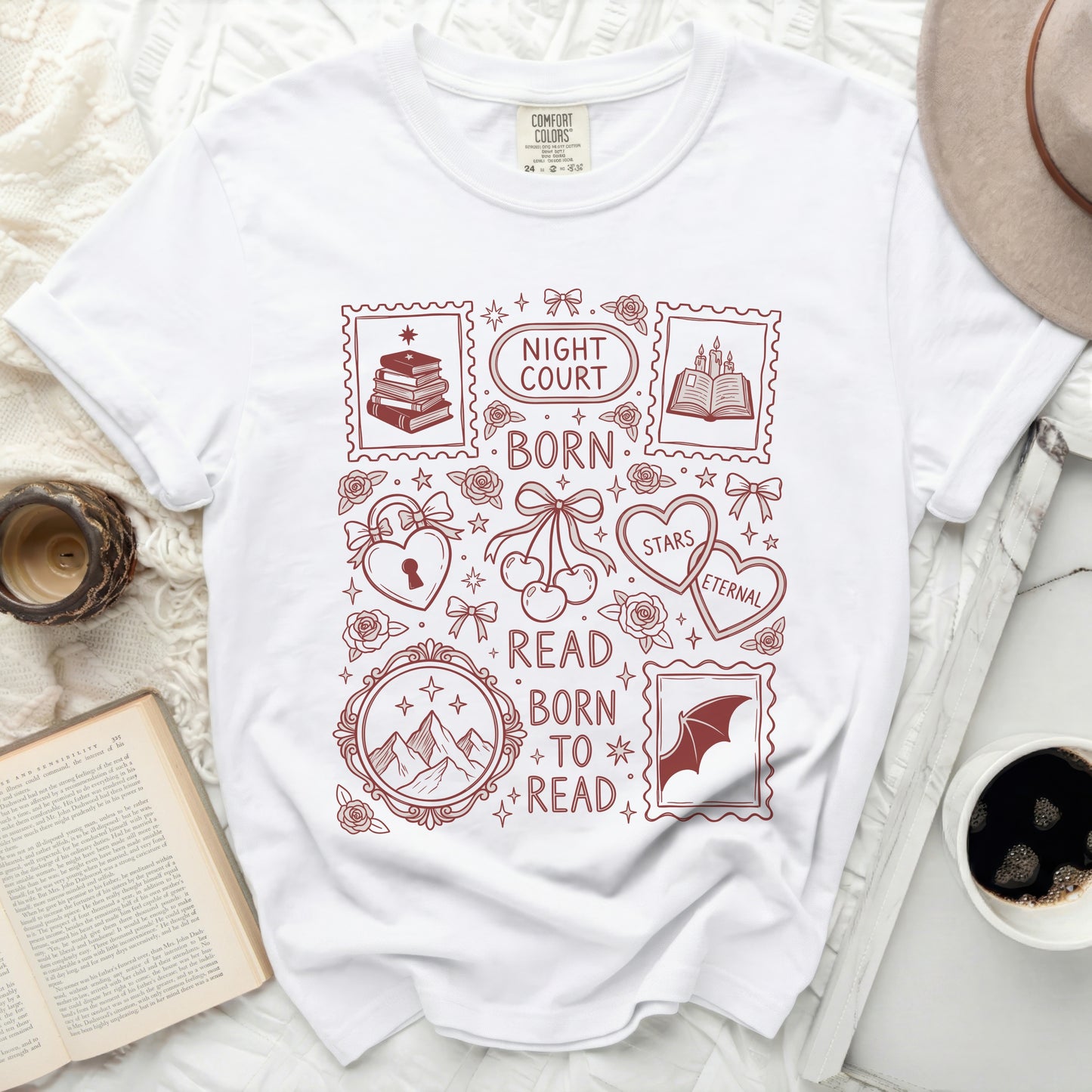 White t-shirt with a dark red graphic of postage stamps featuring books, mountains, hearts, and text.